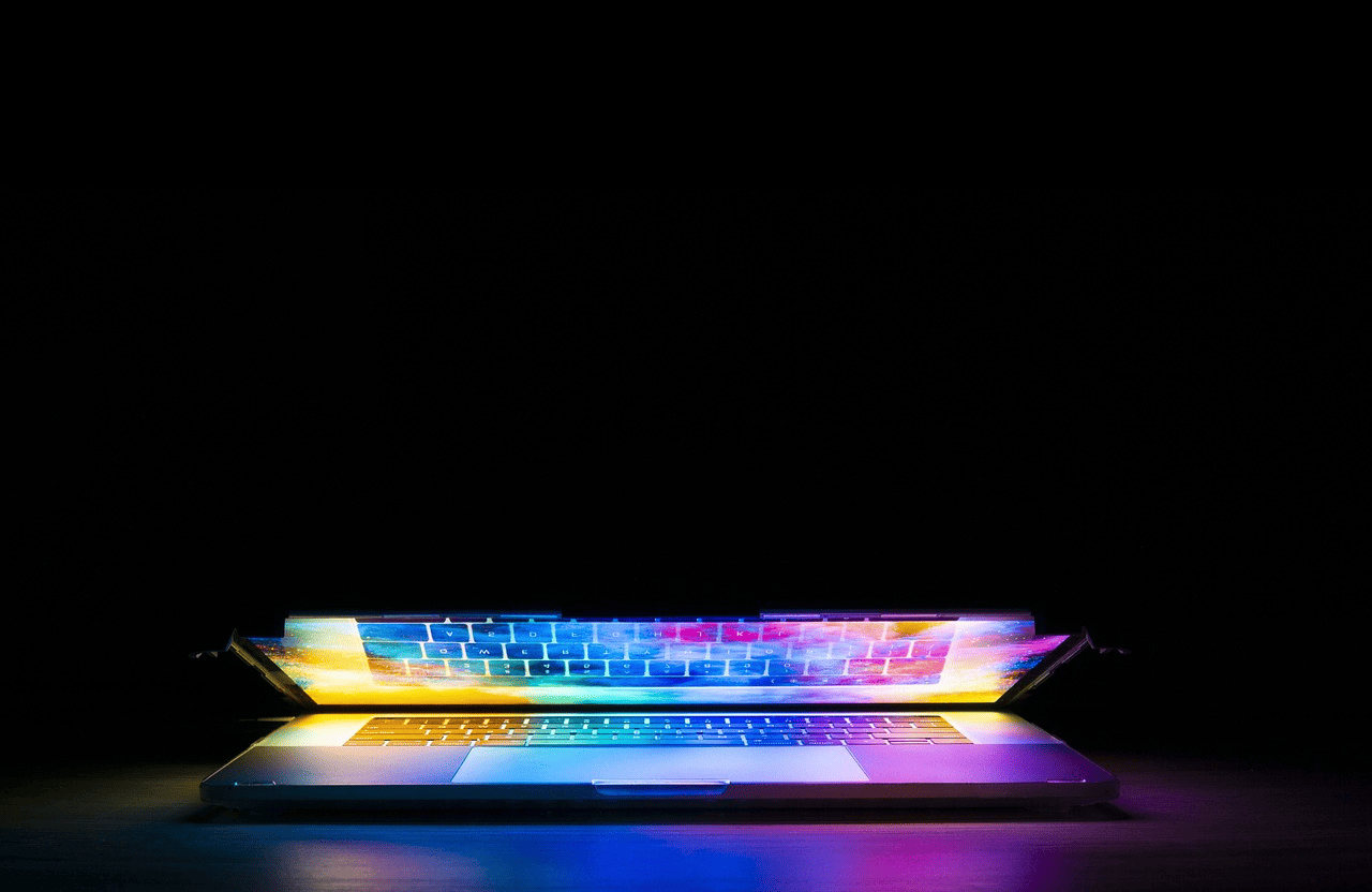 A laptop with rgb lights placed in a dark room that is closing